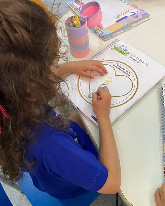 Aluna fazendo atividade no caderno