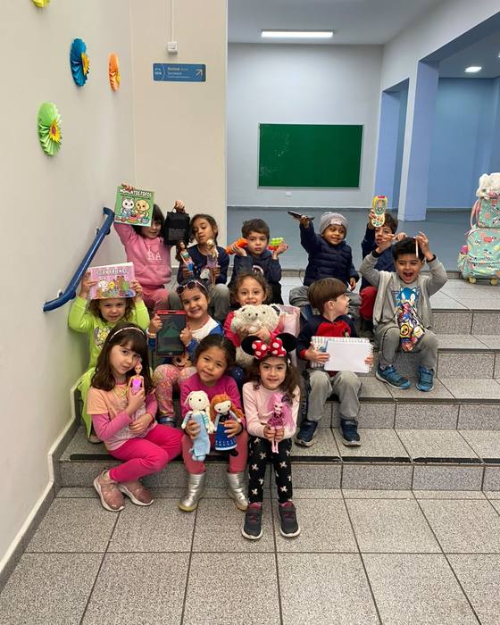 Turma da Educação Infantil na escadaria com seus brinquedos