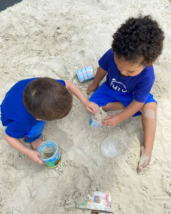 Dois meninos brincando no tanque de areia