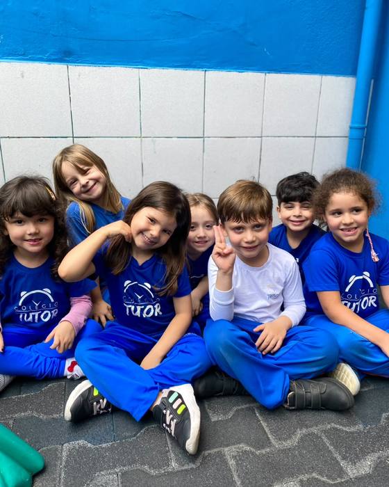 Turma sorrindo sentada junta no pátio