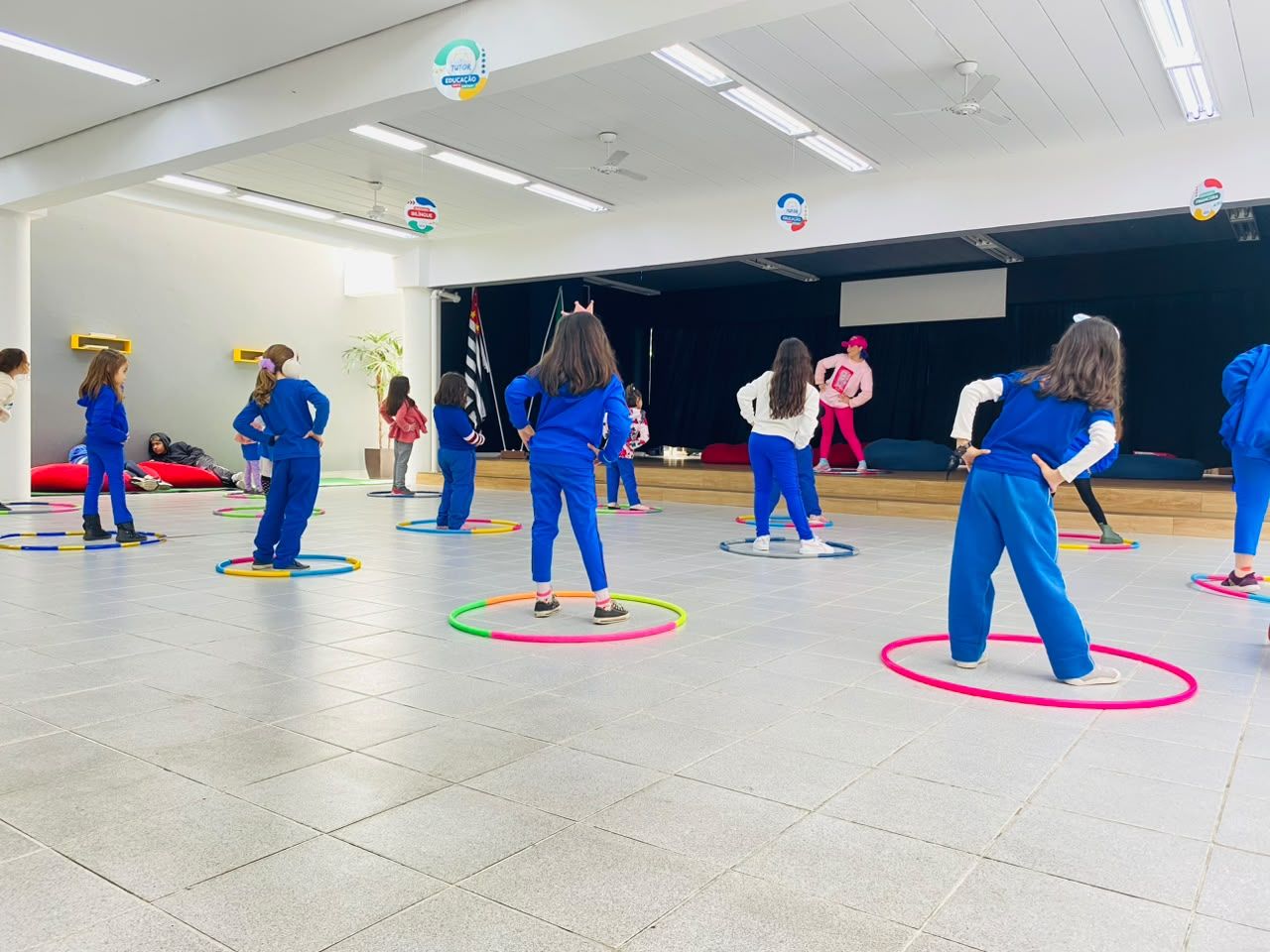 Alunos em atividade com bambolês no auditório